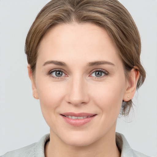 Joyful white young-adult female with medium  brown hair and grey eyes