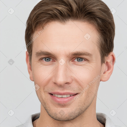 Joyful white young-adult male with short  brown hair and grey eyes