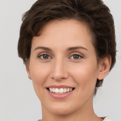 Joyful white young-adult female with short  brown hair and grey eyes