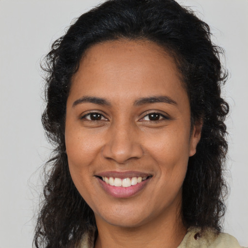 Joyful latino young-adult female with long  brown hair and brown eyes