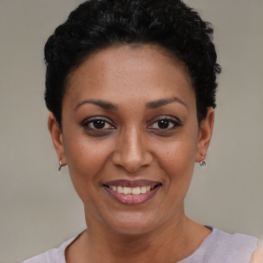 Joyful black young-adult female with short  black hair and brown eyes