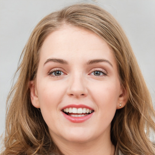 Joyful white young-adult female with long  brown hair and blue eyes