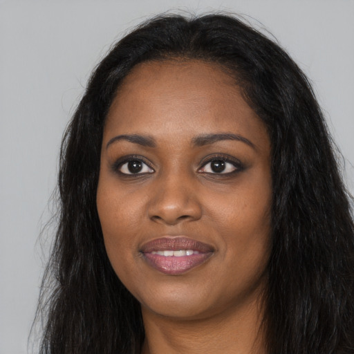 Joyful black young-adult female with long  black hair and brown eyes