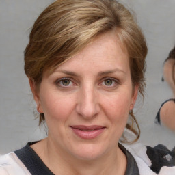 Joyful white adult female with medium  brown hair and blue eyes