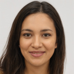 Joyful latino young-adult female with long  brown hair and brown eyes