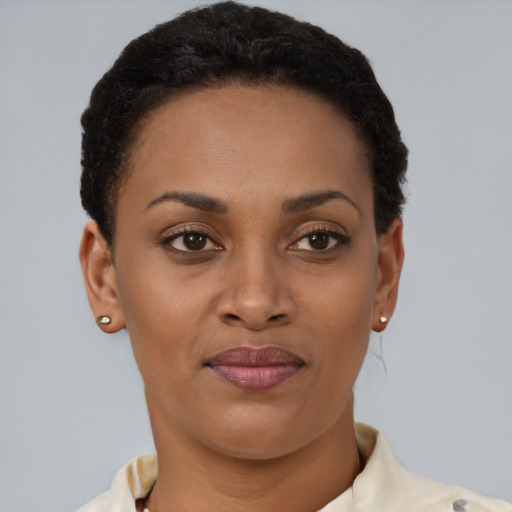 Joyful black young-adult female with short  brown hair and brown eyes