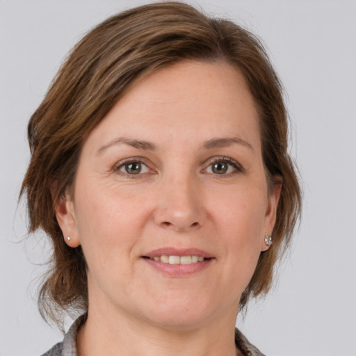 Joyful white adult female with medium  brown hair and grey eyes