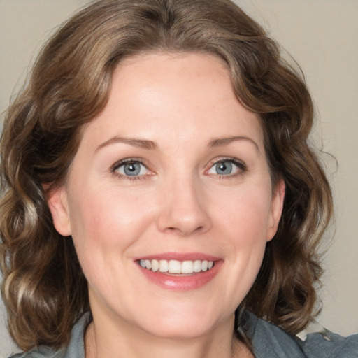 Joyful white young-adult female with medium  brown hair and blue eyes