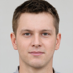 Joyful white young-adult male with short  brown hair and grey eyes