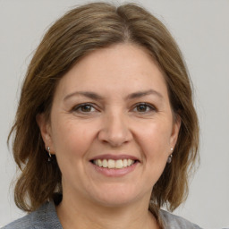 Joyful white adult female with medium  brown hair and grey eyes