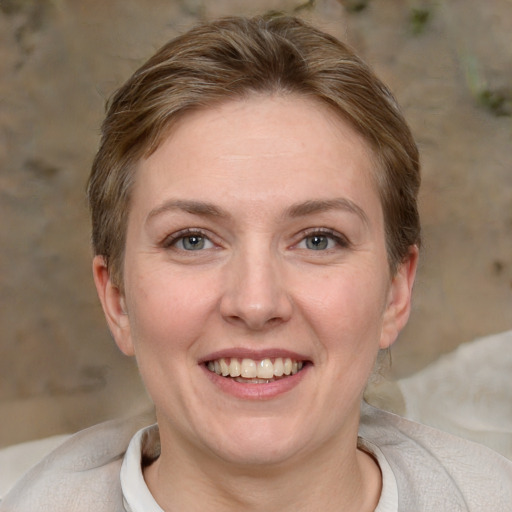 Joyful white young-adult female with short  brown hair and grey eyes