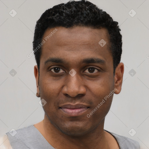 Joyful black young-adult male with short  black hair and brown eyes