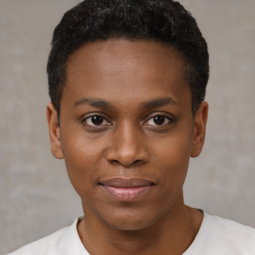 Joyful black young-adult female with short  black hair and brown eyes