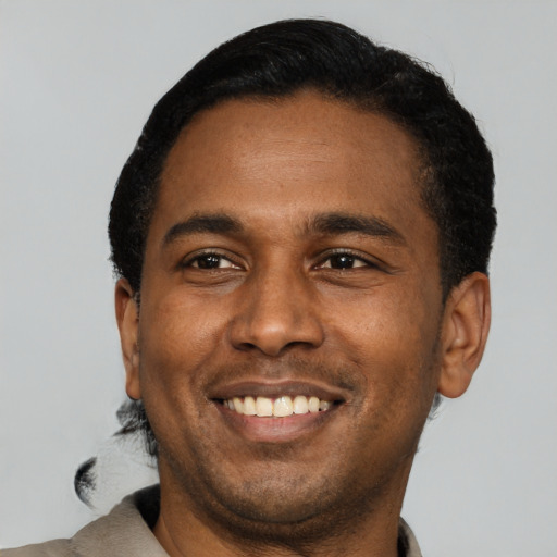 Joyful latino young-adult male with short  black hair and brown eyes