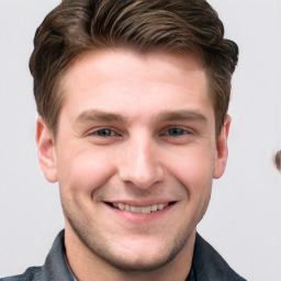 Joyful white young-adult male with short  brown hair and grey eyes