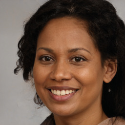 Joyful latino adult female with medium  brown hair and brown eyes