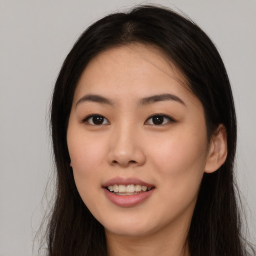 Joyful asian young-adult female with long  brown hair and brown eyes