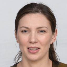 Joyful white young-adult female with medium  brown hair and grey eyes