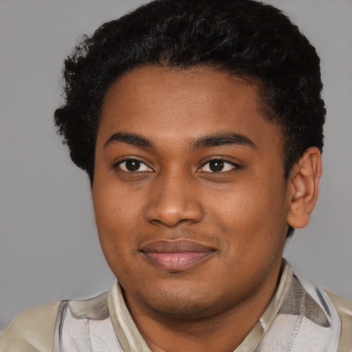 Joyful black young-adult male with short  brown hair and brown eyes