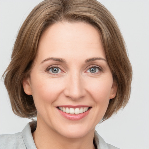 Joyful white young-adult female with medium  brown hair and grey eyes