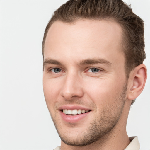 Joyful white young-adult male with short  brown hair and grey eyes