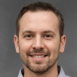 Joyful white adult male with short  brown hair and brown eyes