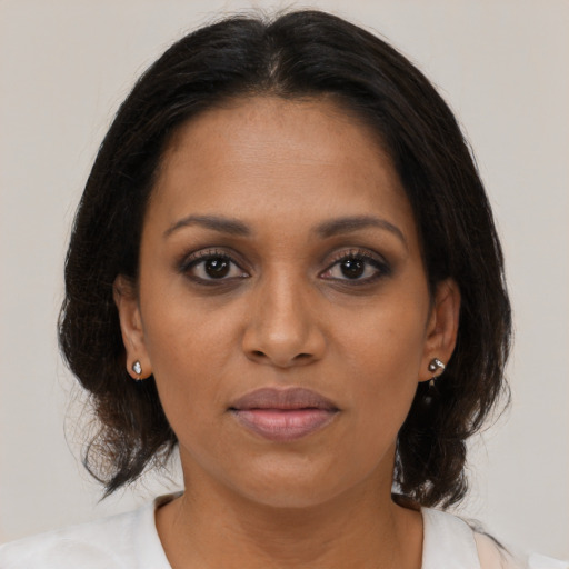 Joyful black adult female with medium  brown hair and brown eyes