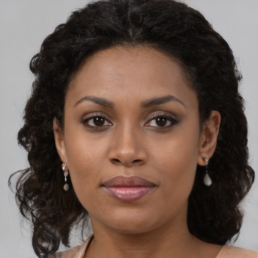 Joyful black young-adult female with medium  brown hair and brown eyes