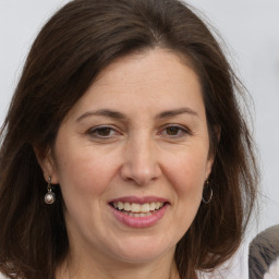 Joyful white adult female with long  brown hair and grey eyes