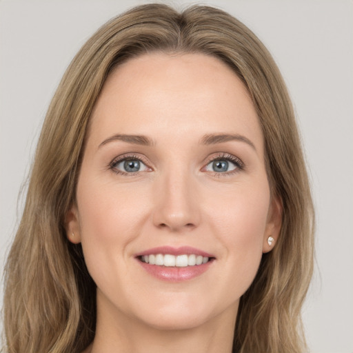 Joyful white young-adult female with long  brown hair and blue eyes