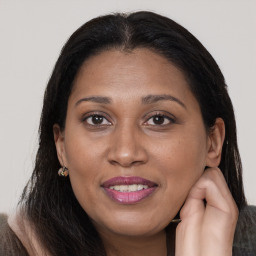 Joyful latino adult female with long  brown hair and brown eyes