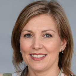 Joyful white adult female with medium  brown hair and grey eyes