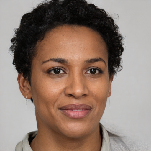 Joyful black adult female with short  brown hair and brown eyes