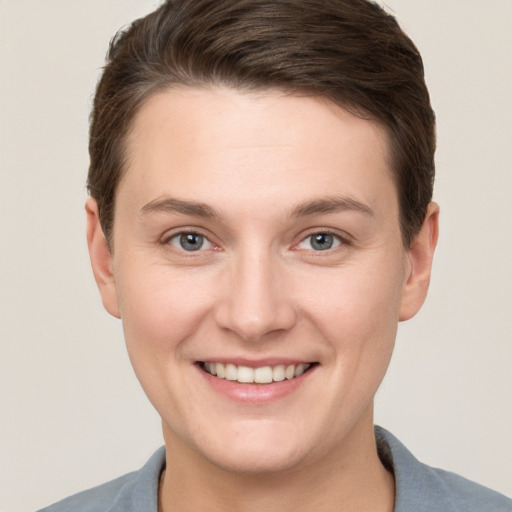 Joyful white young-adult female with short  brown hair and grey eyes