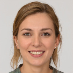 Joyful white young-adult female with medium  brown hair and grey eyes