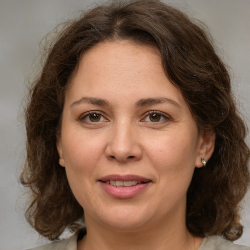 Joyful white adult female with medium  brown hair and grey eyes