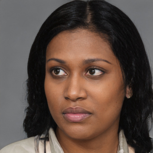 Joyful black young-adult female with long  black hair and brown eyes