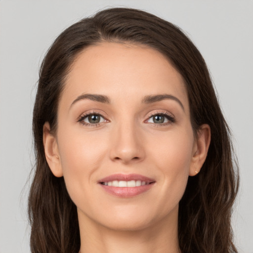 Joyful white young-adult female with long  brown hair and brown eyes