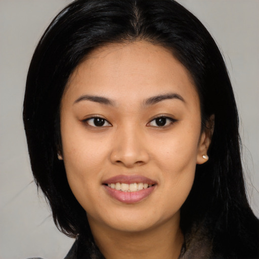 Joyful asian young-adult female with long  black hair and brown eyes