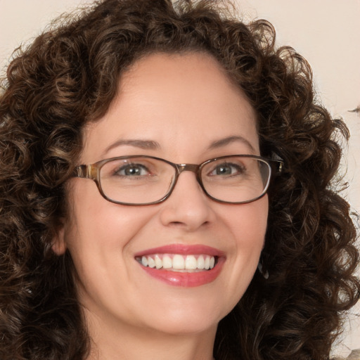 Joyful white adult female with medium  brown hair and green eyes