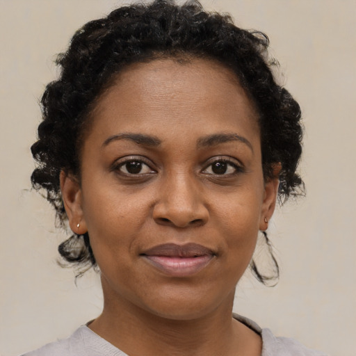 Joyful black adult female with short  brown hair and brown eyes
