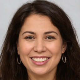 Joyful white adult female with long  brown hair and brown eyes