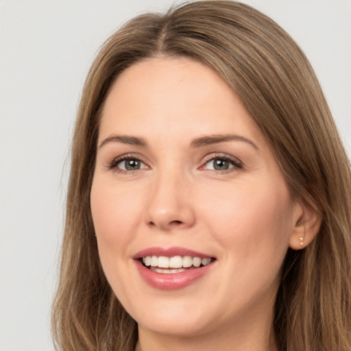 Joyful white young-adult female with long  brown hair and brown eyes