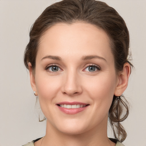 Joyful white young-adult female with medium  brown hair and grey eyes