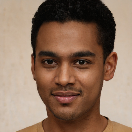 Joyful black young-adult male with short  black hair and brown eyes