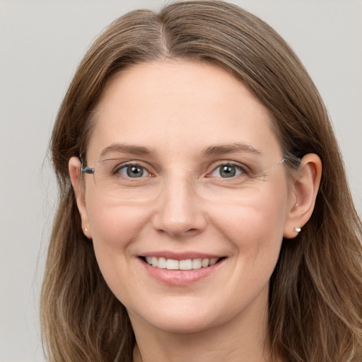 Joyful white young-adult female with long  brown hair and grey eyes