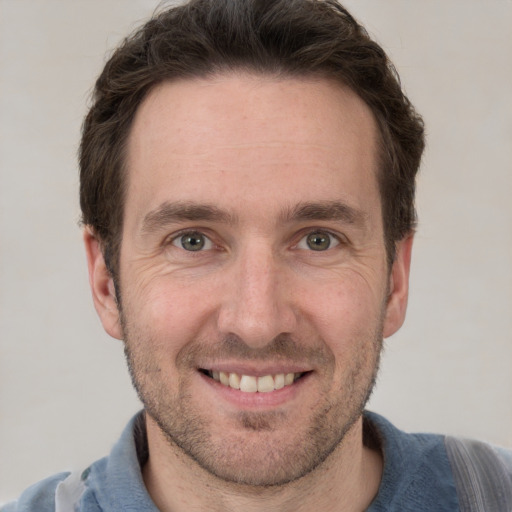 Joyful white adult male with short  brown hair and grey eyes