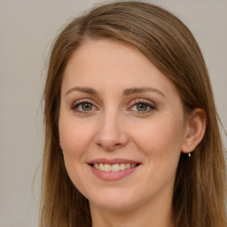 Joyful white young-adult female with long  brown hair and grey eyes