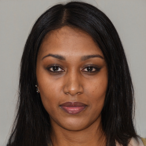 Joyful black young-adult female with long  black hair and brown eyes