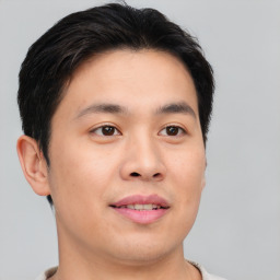 Joyful asian young-adult male with short  brown hair and brown eyes